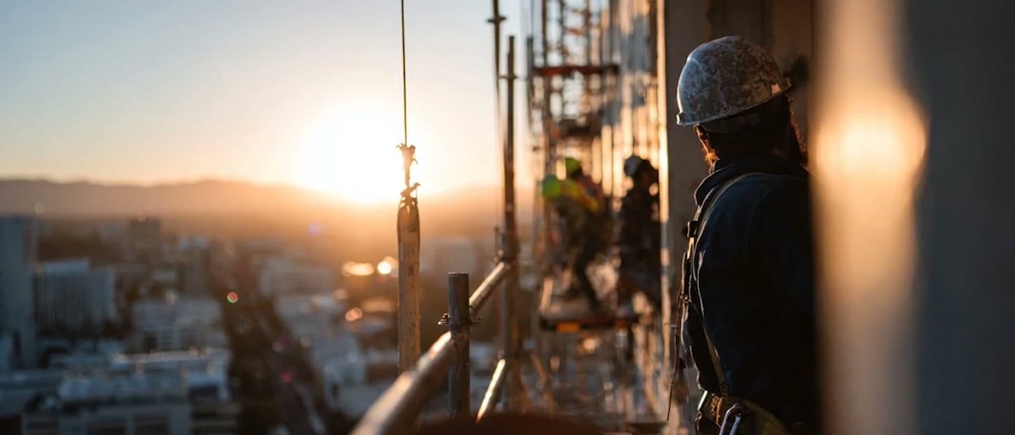 Construction worker on scaffolding at sunset from the Building Blocks Facades film proposal